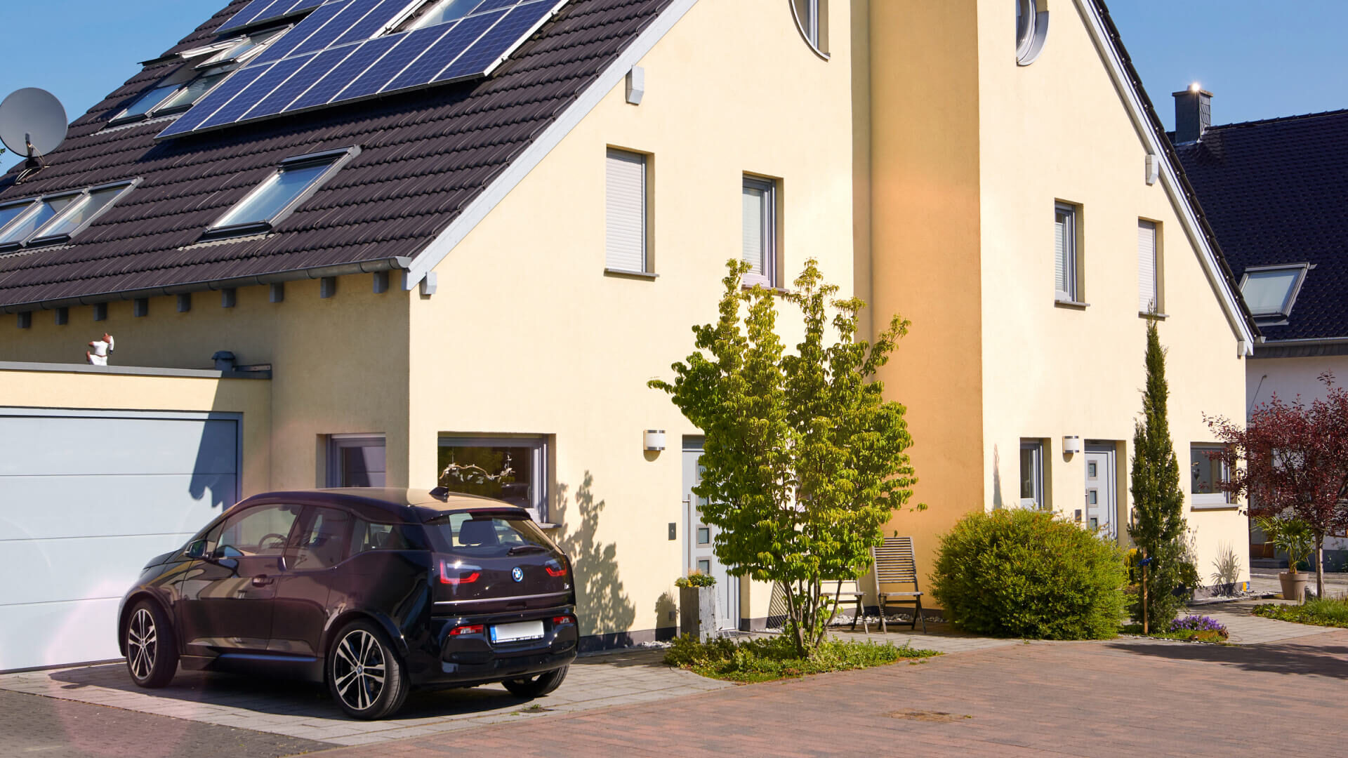 E-Auto lädt mit der Energie aus der Solaranlage auf dem Dach des Hauses